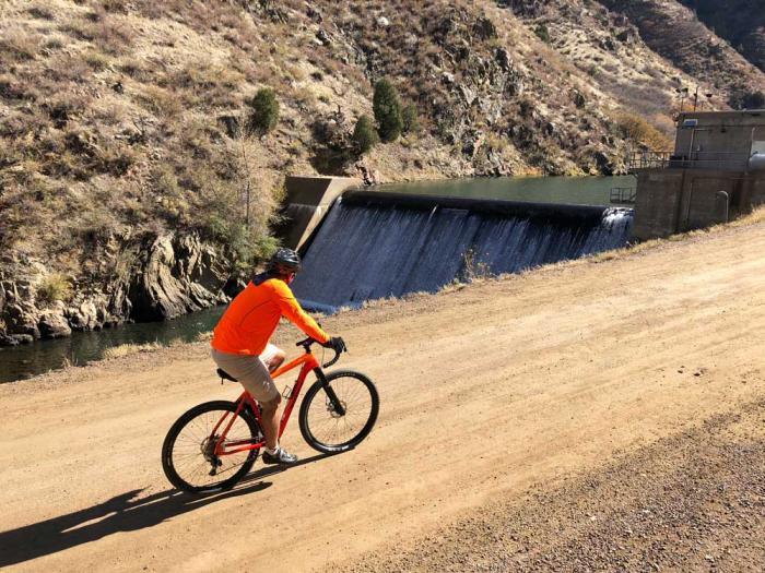 在沃特顿峡谷的南普拉特河边，一名身穿红色衬衫的自行车骑手骑在土路上。