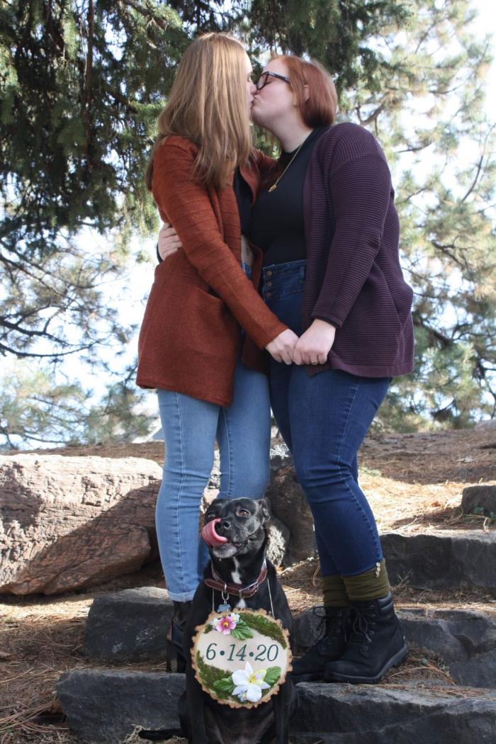 凯特·康特(左)和凯西庆祝他们和心爱的小狗萝拉订婚，萝拉的牌子上写着他们原定的2020年结婚日期。照片来源:凯特计数器。