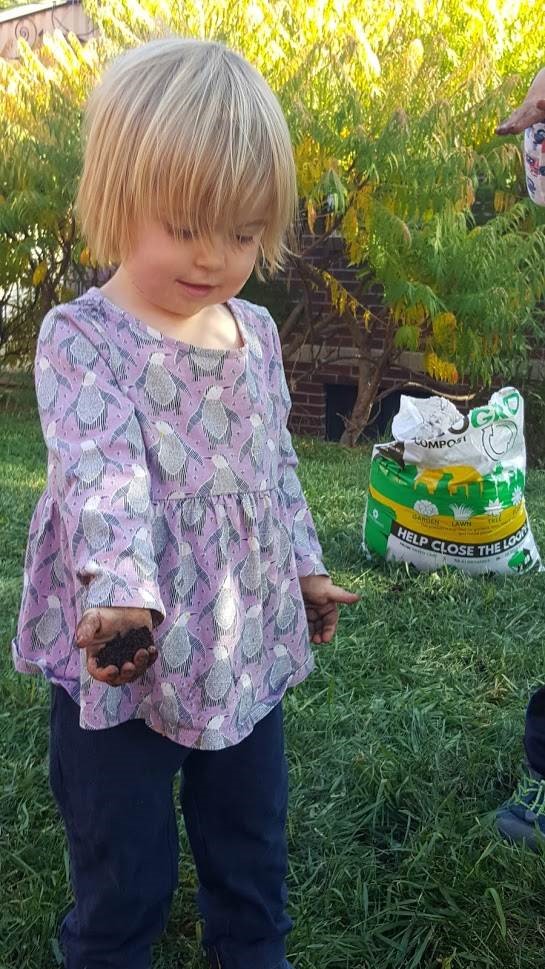 瑟琳娜·特杰拉尔帮助她的家人在草坪上铺上EcoGro。这种堆肥来源于丹佛的可堆肥废物。图片来源:Denver Water