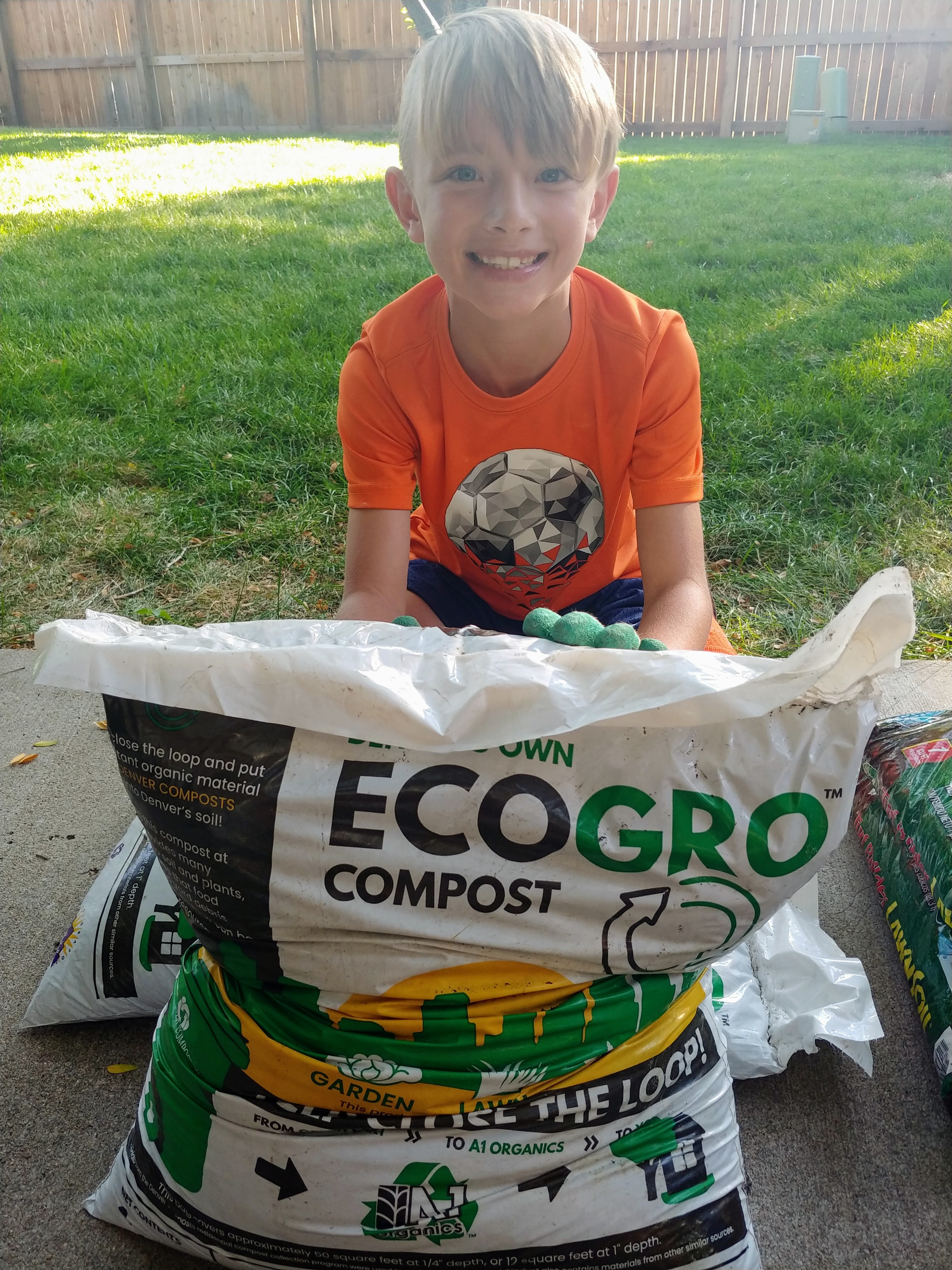 8岁的基顿·德林科准备把当地生产的堆肥放在草地上，帮助他的父母为一个健康、节水的春天准备草坪。