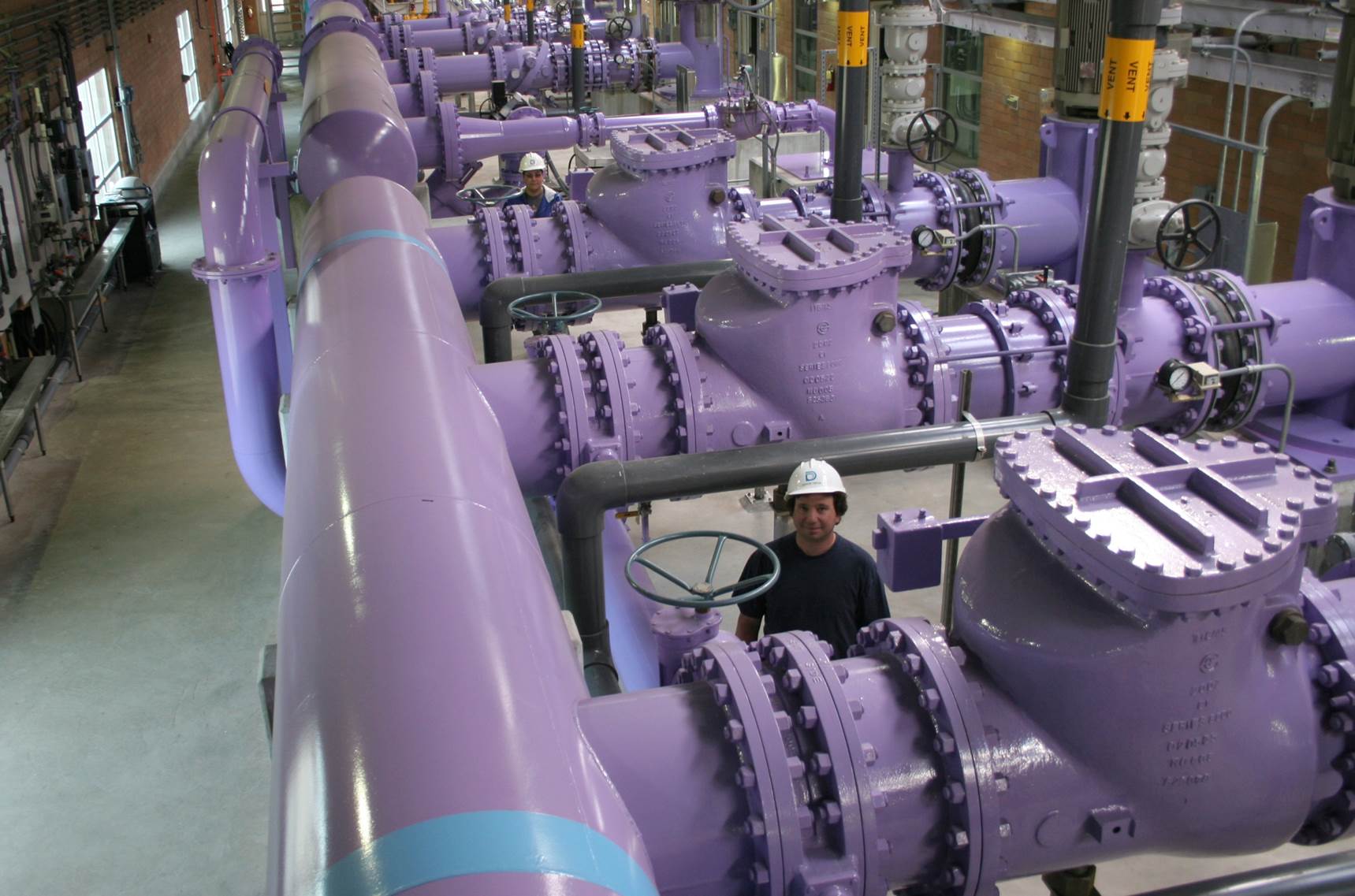 施工人员正在丹佛的斯台普顿社区安装一段20英尺长的紫色管道。